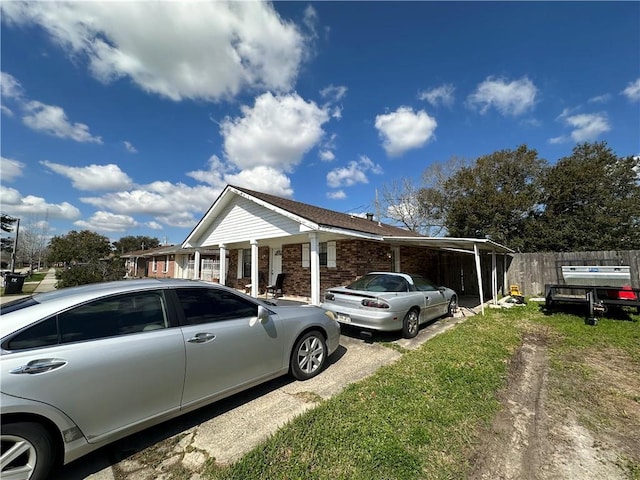 view of side of property featuring fence and brick siding