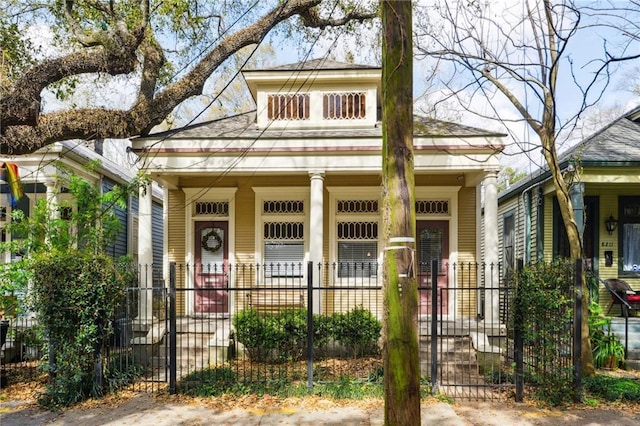 view of front of home with a fenced front yard and a porch