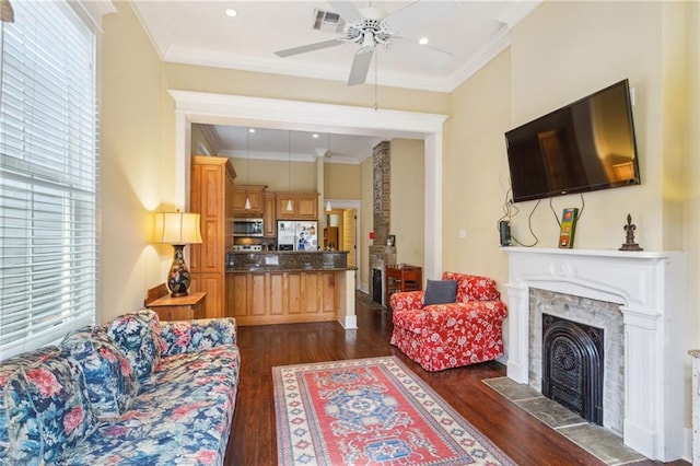 living area with visible vents, dark wood-style flooring, a high end fireplace, and crown molding