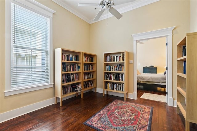 living area with crown molding, wood finished floors, baseboards, and ceiling fan