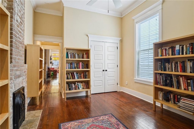 living area with plenty of natural light, crown molding, a fireplace with flush hearth, and hardwood / wood-style floors