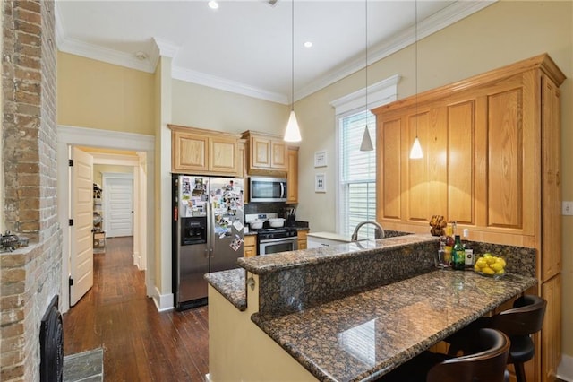 kitchen with ornamental molding, dark wood finished floors, dark stone counters, a peninsula, and appliances with stainless steel finishes