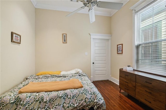 bedroom with dark wood-type flooring, crown molding, baseboards, and ceiling fan