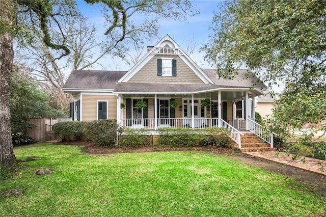 view of front of home featuring a front lawn, fence, and covered porch