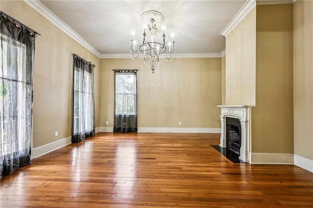 unfurnished living room featuring hardwood / wood-style flooring, a fireplace with flush hearth, baseboards, and ornamental molding