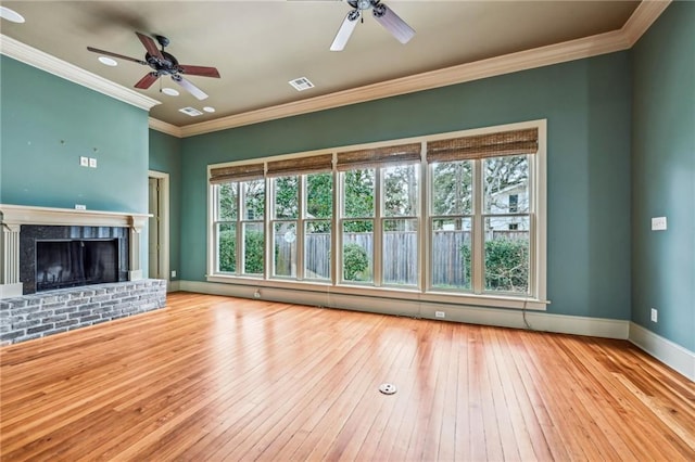 unfurnished living room with hardwood / wood-style floors, a brick fireplace, baseboards, and visible vents