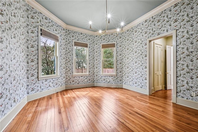 unfurnished room with hardwood / wood-style flooring, wallpapered walls, and ornamental molding