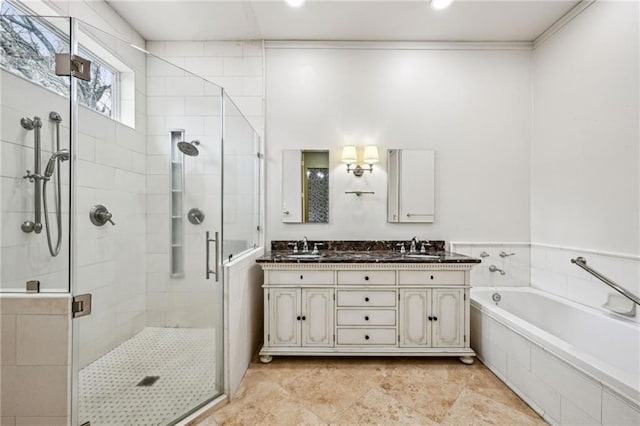 full bathroom featuring a bath, a sink, a shower stall, and double vanity