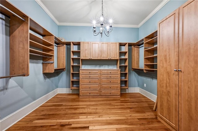 spacious closet with an inviting chandelier and wood finished floors