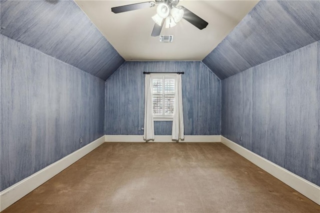 additional living space featuring visible vents, baseboards, lofted ceiling, carpet flooring, and a ceiling fan