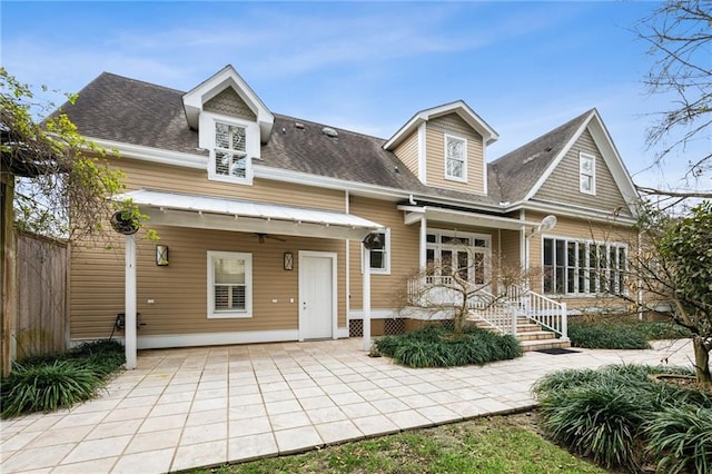 rear view of house with roof with shingles