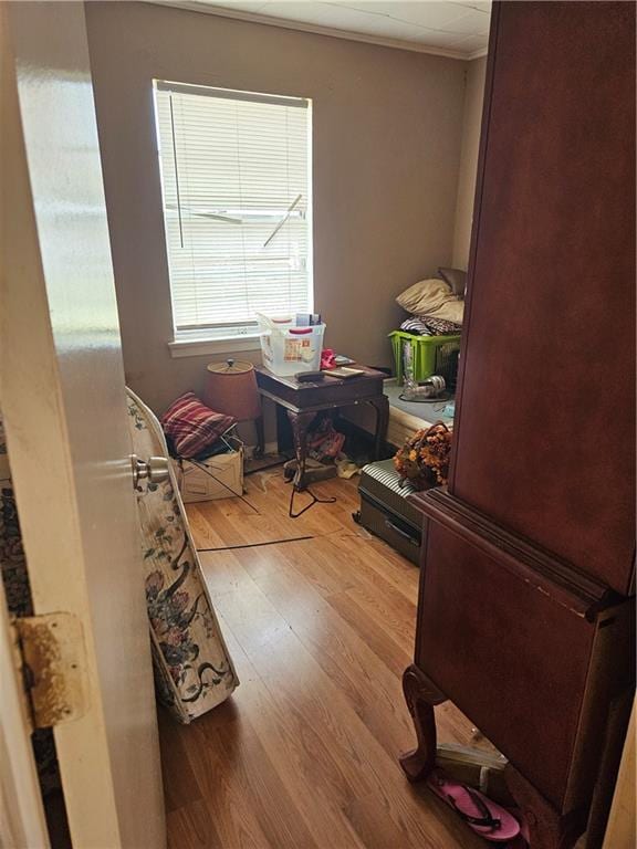 bedroom with wood finished floors and crown molding