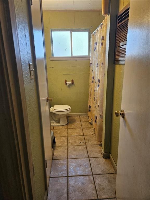 full bath featuring tile patterned flooring, curtained shower, and toilet