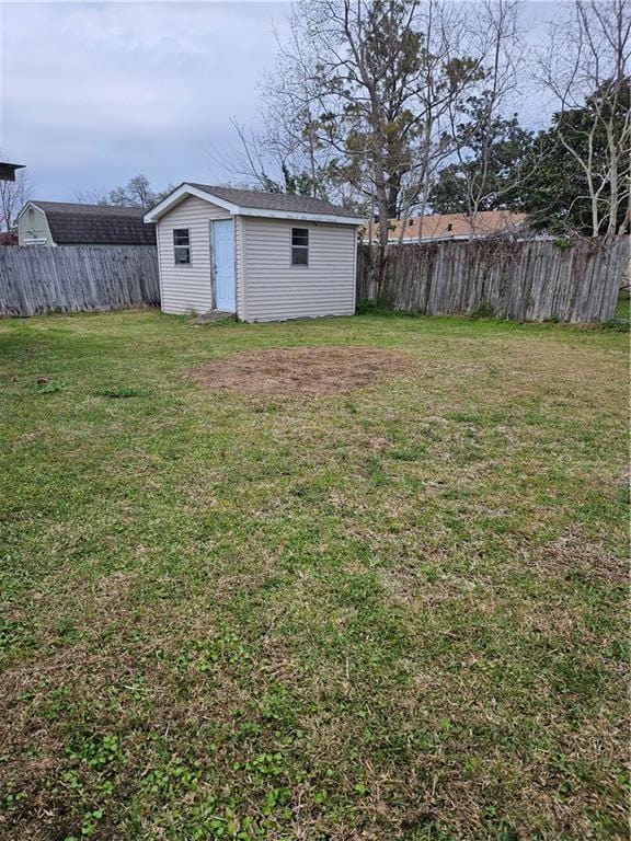 view of yard with a storage shed, an outdoor structure, and a fenced backyard