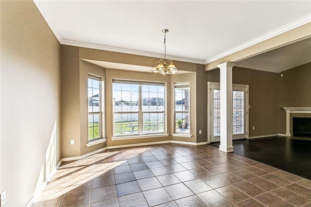 interior space with a chandelier, a fireplace, baseboards, and ornate columns