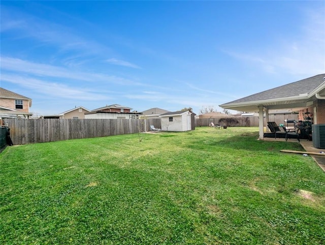 view of yard featuring a storage unit, a fenced backyard, a patio, and an outdoor structure