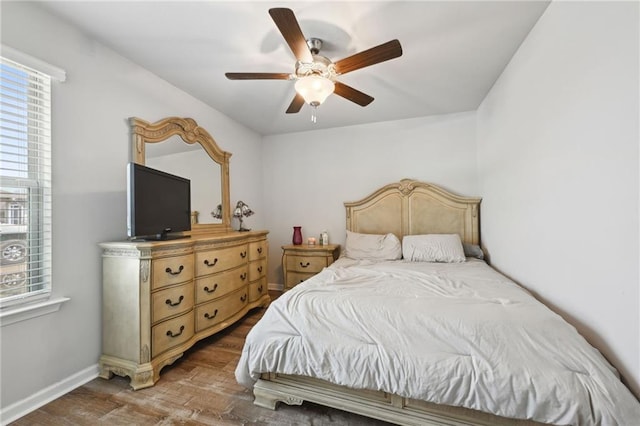 bedroom with baseboards, wood finished floors, and a ceiling fan