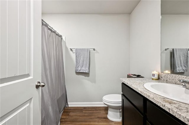 full bath featuring toilet, curtained shower, wood finished floors, baseboards, and vanity