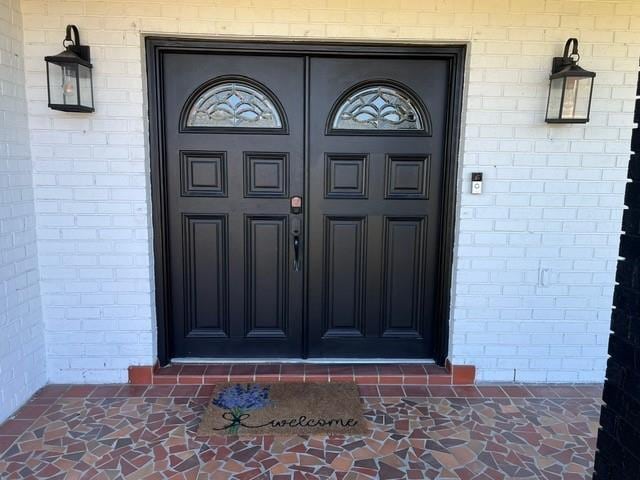 view of exterior entry featuring brick siding