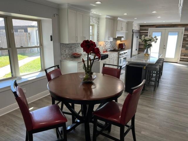 dining room featuring plenty of natural light, french doors, baseboards, and wood finished floors