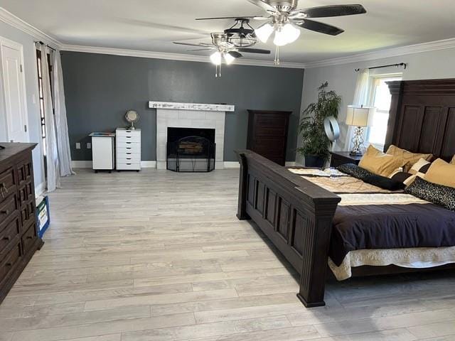 bedroom with a ceiling fan, baseboards, light wood-style floors, and crown molding