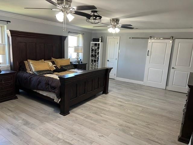 bedroom with light wood-style floors, crown molding, and a barn door