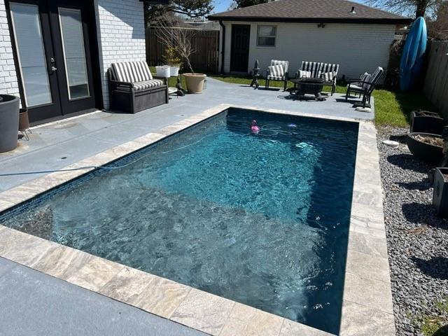 view of pool featuring a fenced backyard, a fenced in pool, french doors, and a patio