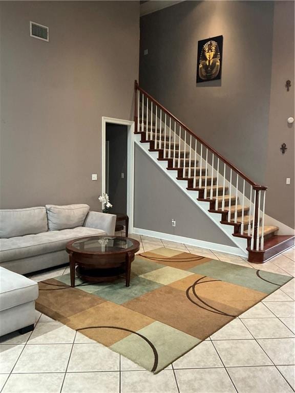 tiled living area with visible vents, stairs, and baseboards