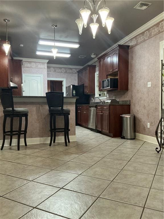 kitchen with stainless steel appliances, dark countertops, crown molding, and wallpapered walls