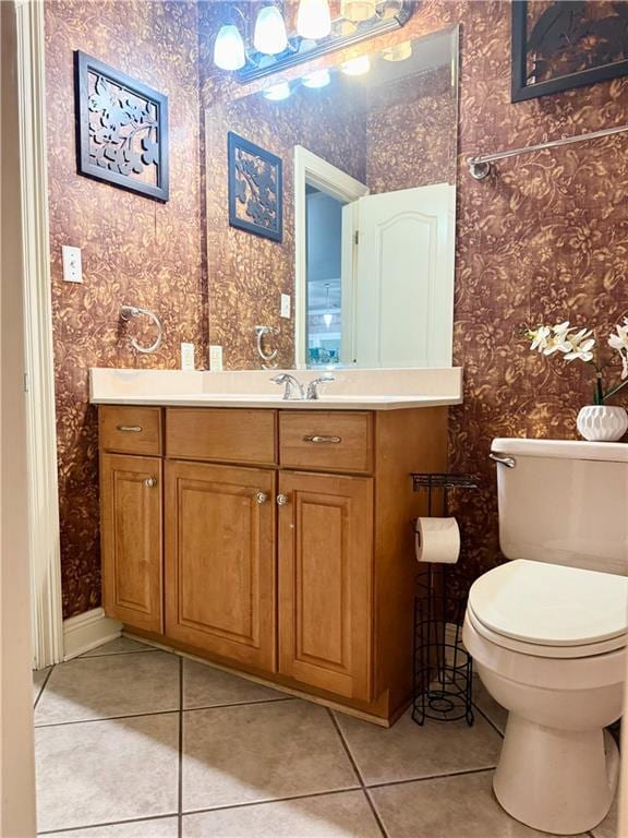 bathroom with tile patterned floors, toilet, vanity, and wallpapered walls