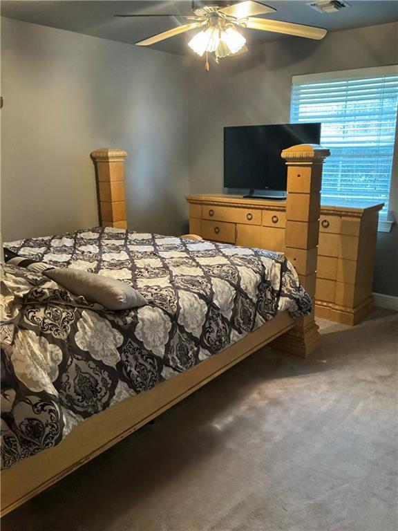 carpeted bedroom featuring visible vents and ceiling fan