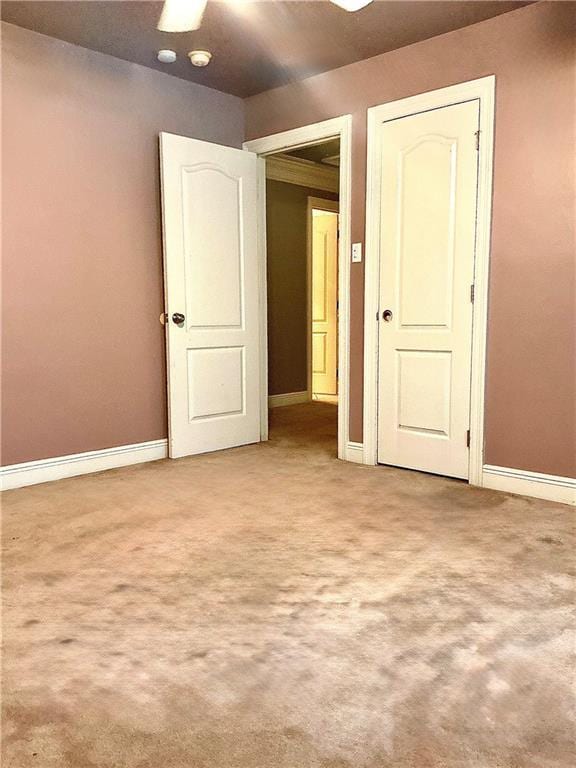 interior space featuring baseboards and light carpet