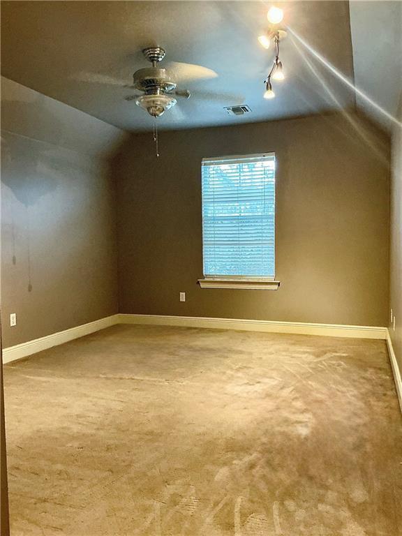 additional living space with visible vents, carpet floors, baseboards, and vaulted ceiling