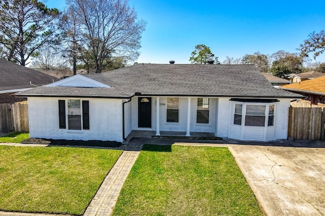 ranch-style home featuring a front lawn, fence, brick siding, and roof with shingles