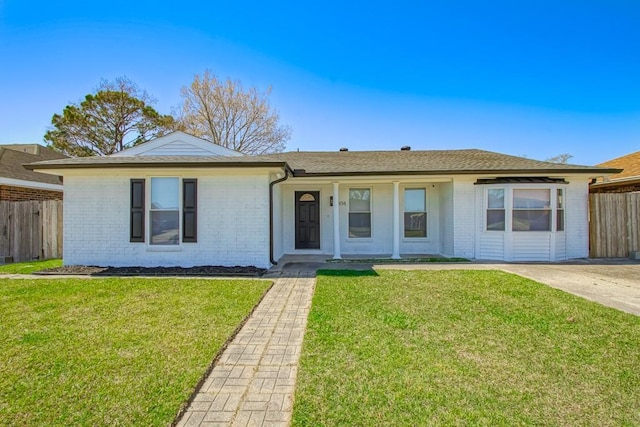 single story home with brick siding, a shingled roof, a front yard, and fence