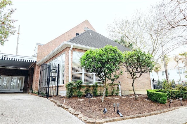 view of front of property with brick siding and a shingled roof