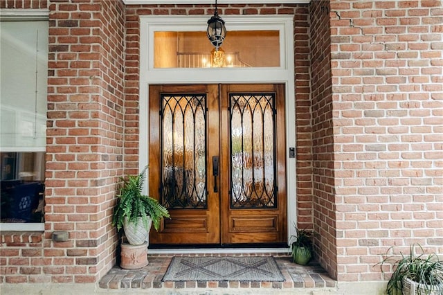 doorway to property featuring brick siding and french doors