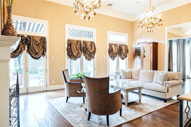 living area with a chandelier, wood finished floors, a towering ceiling, and ornamental molding