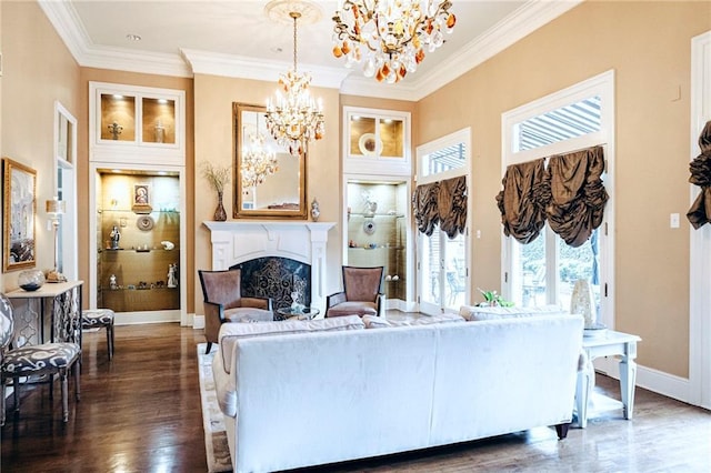 living area with dark wood-style floors, baseboards, an inviting chandelier, a fireplace, and ornamental molding