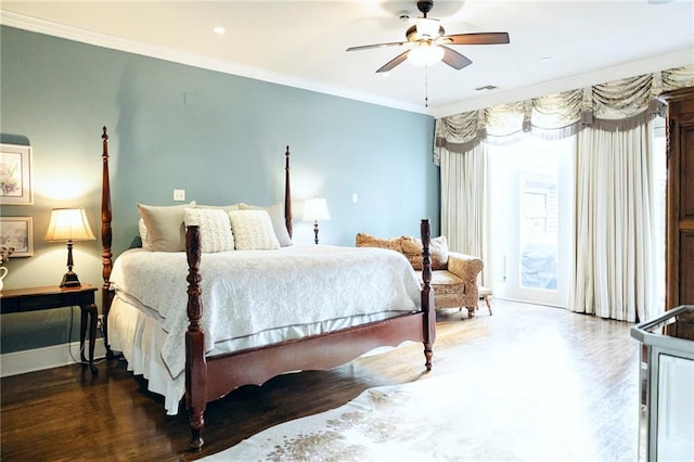 bedroom featuring visible vents, wood finished floors, baseboards, and ornamental molding