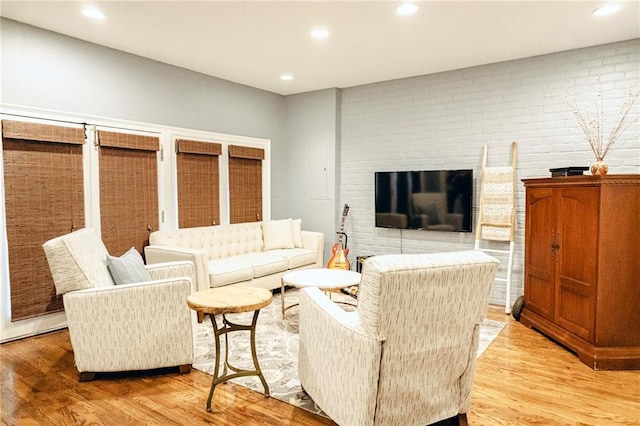 living room with recessed lighting, a fireplace, and light wood-type flooring