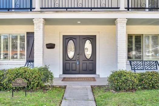 doorway to property featuring a porch and a balcony