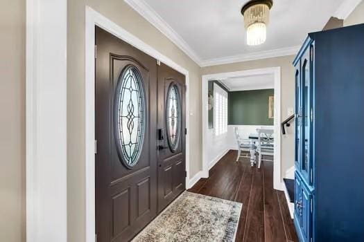 foyer entrance with dark wood-style floors, baseboards, and ornamental molding