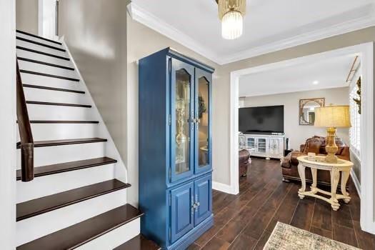 interior space with crown molding, wood finished floors, and baseboards