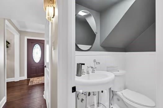 bathroom with a wainscoted wall, toilet, and wood finished floors