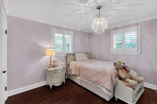 bedroom featuring baseboards, a notable chandelier, and wood finished floors