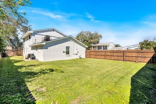 rear view of property featuring a yard and fence