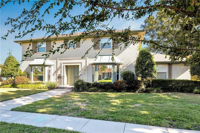 view of front of home featuring a front yard and brick siding