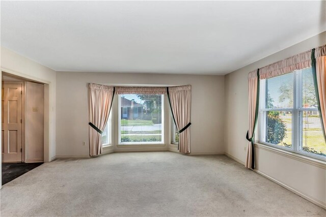 carpeted spare room featuring baseboards