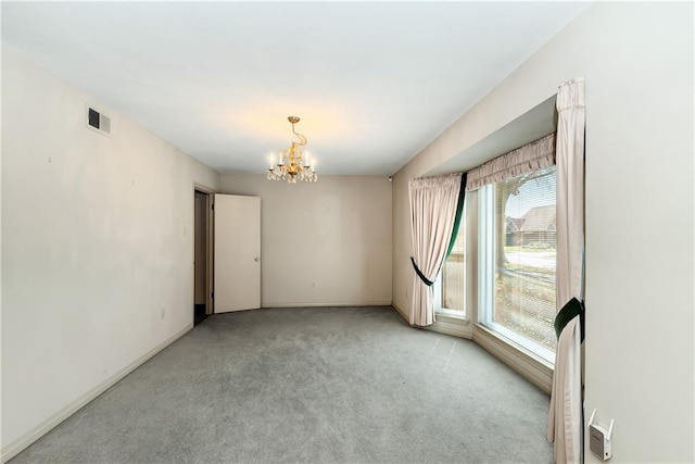 empty room with a chandelier, visible vents, light colored carpet, and baseboards